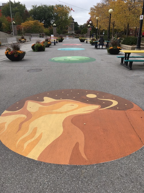 An illustration of a wolf, painted onto the roadway.